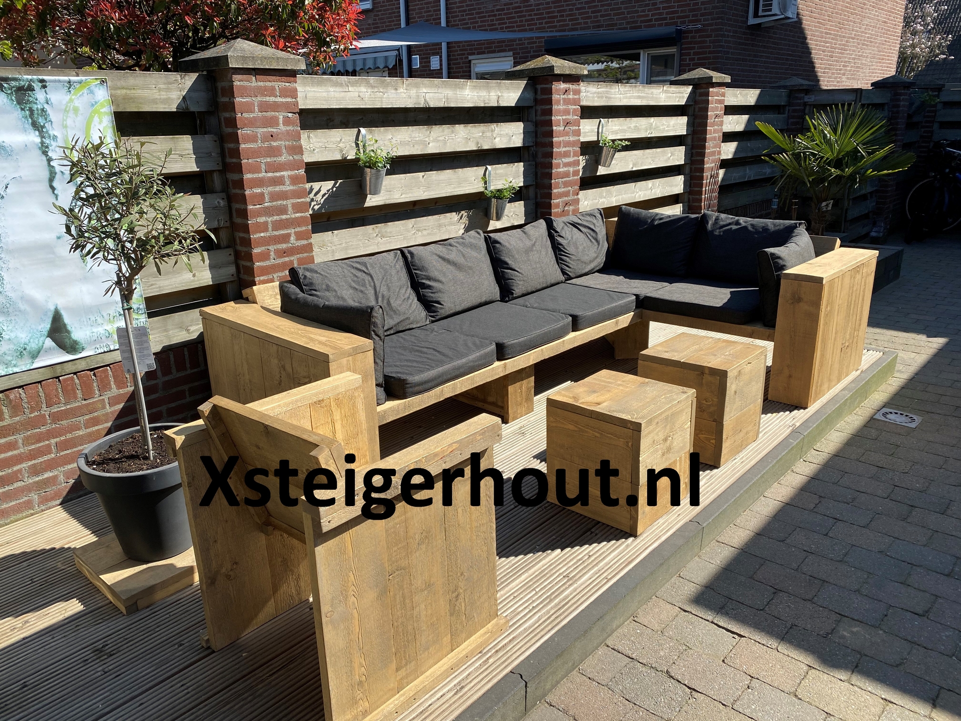 Steigerhout hoekbank en een tuinstoel voor een schutting