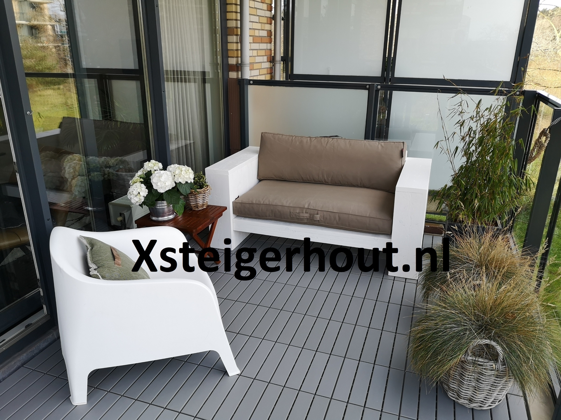 Diepe witte steigerhout loungebank op maat van kussen met een palletkussen op een balkon